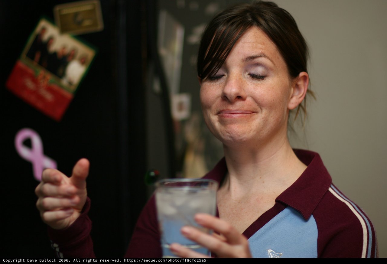 Woman with Drink Gives Thumbs Up at Party