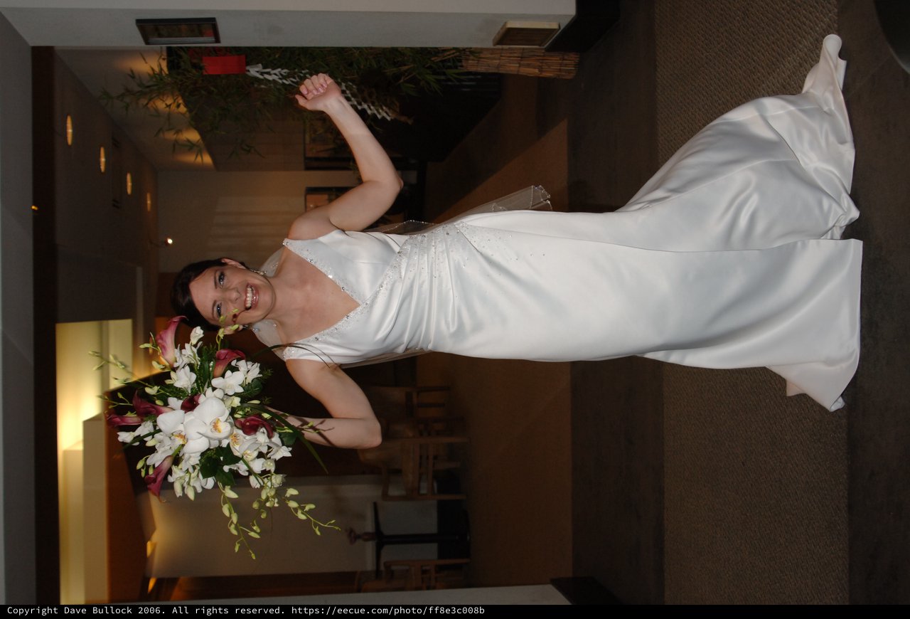 Triumphant Bride Raises Bouquet in Wedding Celebration