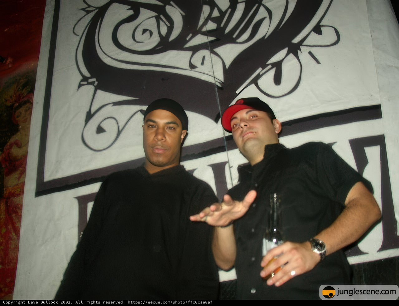 Two Men Posing in Front of a Sign