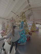 Woman Decorating Bright Turquoise Christmas Tree Display