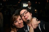 Friends Embrace at a Dimly Lit Bar Night