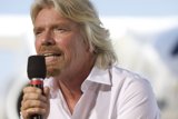 Richard Branson Addressing Crowd with Microphone