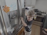 Young Boy Opening Refrigerator in Modern Kitchen