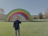 Man Posing with Giant Rainbow Art Installation