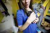 Woman Tenderly Cradling a Tiny Newborn Kitten