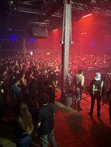 Red-Lit Concert Crowd from Side Stage View