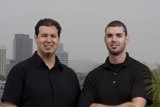 Two Men Posed with Skyscraper Building