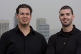 Two Men Posing in Front of a Skyscraper