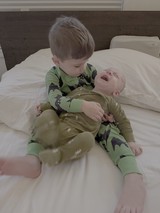 Big Brother Meeting Baby Sibling on Bed