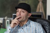 Contemplative Man in Fedora Hat at His Desk