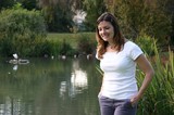 Woman Smiling by a Peaceful Park Pond