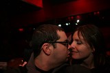 Intimate Moment: Couple Kissing in Dimly Lit Bar