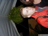 A Man in a Red Jacket Poses with a Potted Plant and Tree