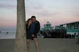 Couple Embracing by Palm Tree at Sunset Pier