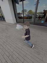 Young Boy Enjoying Cotton Candy Outside Store