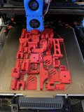 Red plastic car model being printed by 3D printer