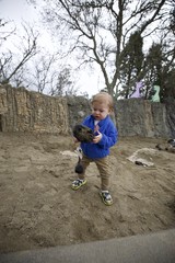 Toddler Exploring Sandy Play Area with Shovel