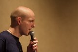 Bald Entertainer Holds Microphone for Solo Performance