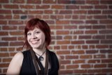 Red-Haired Woman Poses with Brick Wall