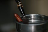 Spoon and Wooden Stick in Metal Bowl