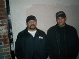 Two Men in Black Jackets Sporting Caps