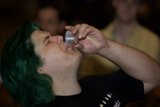 Green-Haired Man Sipping from a Tin Cup
