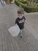 Young Boy Enjoying Cotton Candy Outdoors