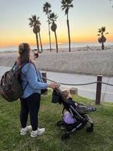 Mother Capturing Sunset Moment with Child at Beach