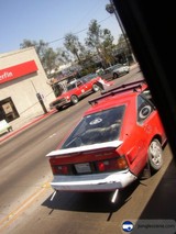 Red sports car parked at a gas station