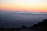 Two Silhouettes Watching Sunset Over Layered Mountain Valleys