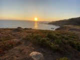 Sunset over Rocky Hillside and Ocean