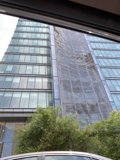 Parked Car in Front of Sky-High Office Building