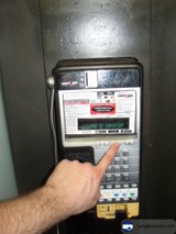 Man Touching Keypad of a Machine