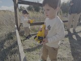Children Playing with Yellow Toy Trucks Outdoors