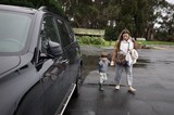 Mother and Child Walking to Car on Rainy Day