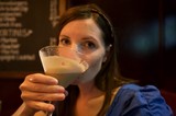 Woman Savoring a Frothy Cocktail at Bar