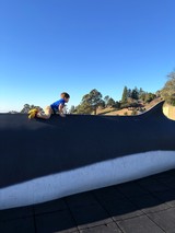 Young Boy Climbing on Curved Skate Ramp at Dusk