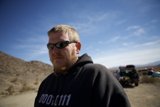 Man in a Hoodie and Sunglasses Embracing the Desert