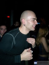 Tattooed Bald Man Performing with Microphone