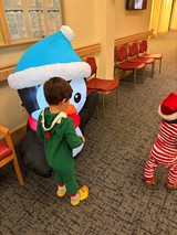 Child Hugging Inflatable Snowman Character in Waiting Room