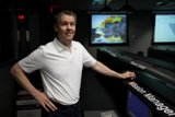 Man working on three screens