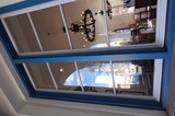Blue-Framed Window View into Mediterranean Restaurant Interior