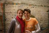 Two Women Posed in Front of Brick Wall