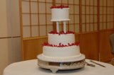 Elegant Three-Tiered Wedding Cake with Red Flowers