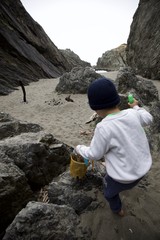Young Explorer Navigating Rocky Beach Cove Adventure