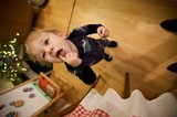 Joyful Toddler Enjoying Lollipop on Christmas Morning