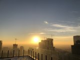 Rising Sun and Cityscape with Construction Cranes