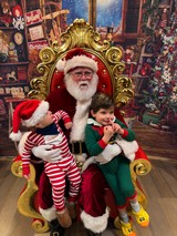 Two Children Visit Santa in His Workshop Throne