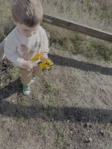 Child Playing with Toy Truck Outdoors