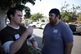 Two Men Chatting by the Cars